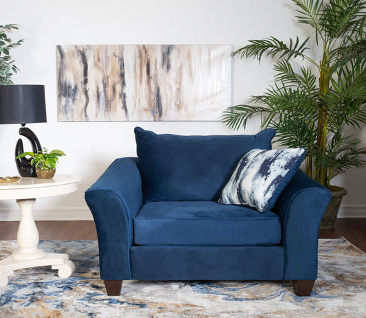 Plush navy blue armchair with tapered wooden legs and a decorative throw pillow