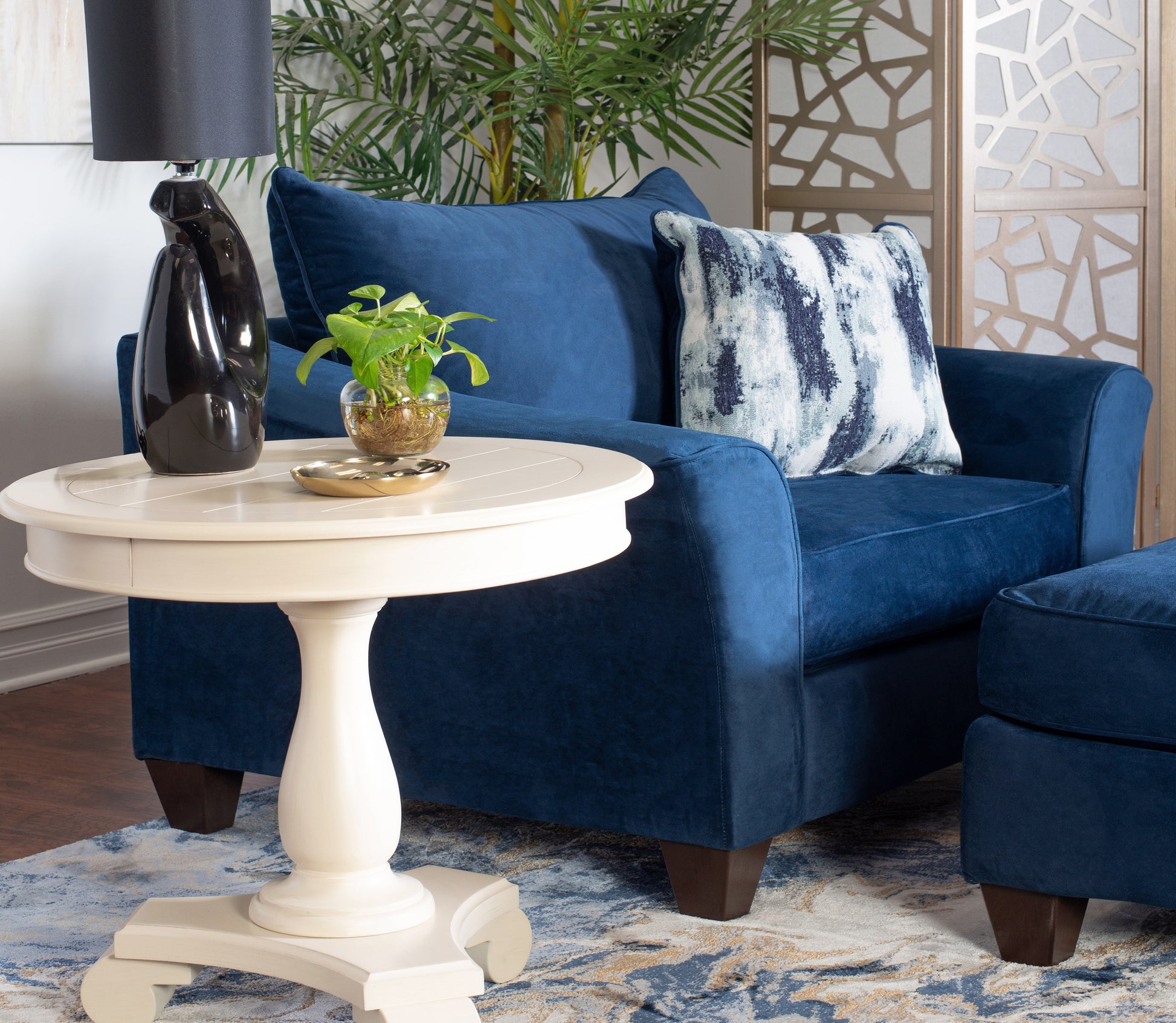 Plush navy blue velvet armchair with a matching ottoman perfect for a cozy living room setup