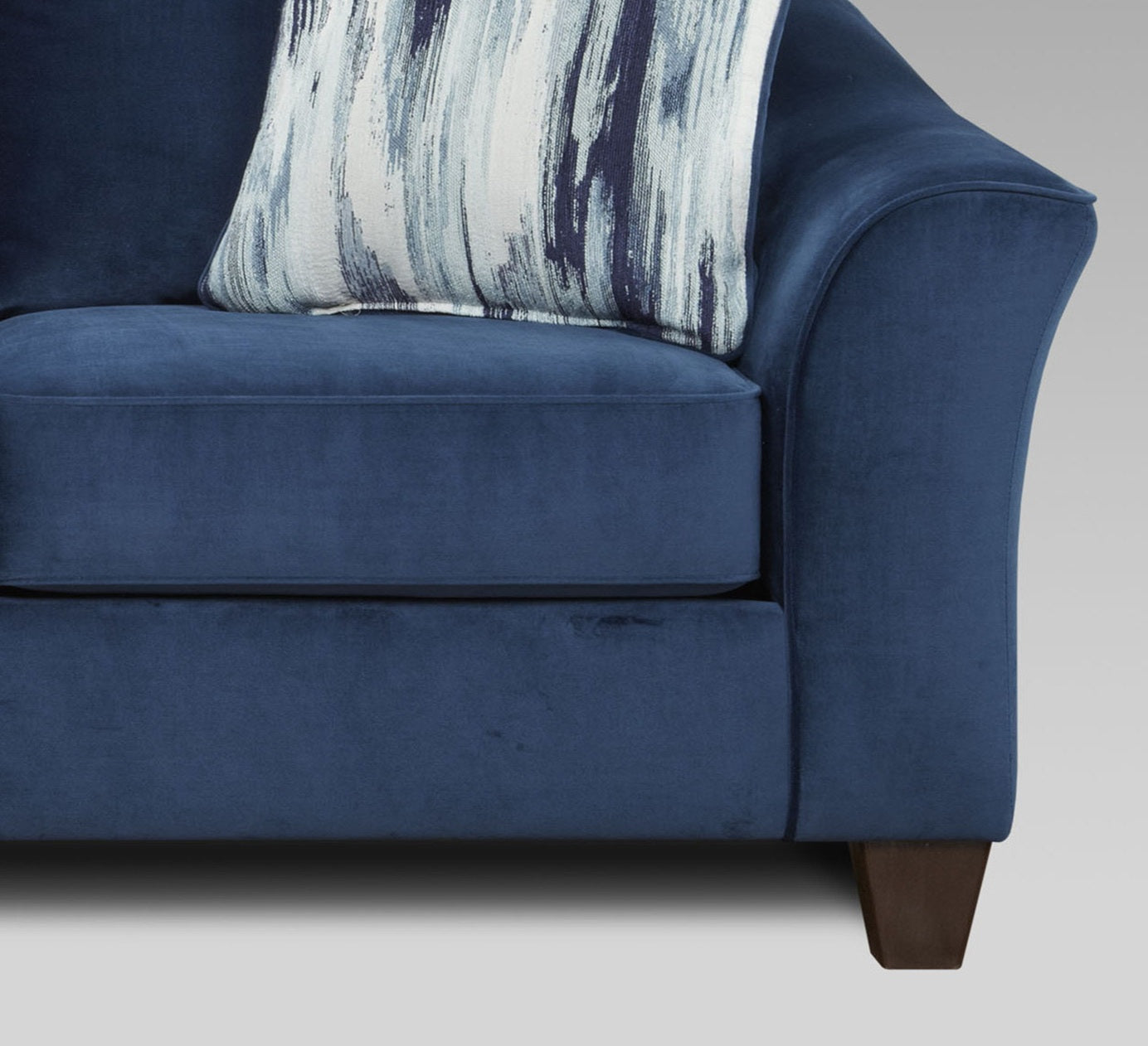 Deep navy velvet sofa with abstract patterned accent cushion for living room comfort