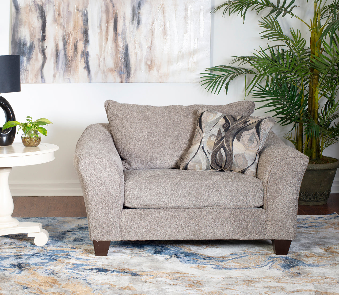 Plush taupe fabric accent chair with decorative grey and beige patterned pillow