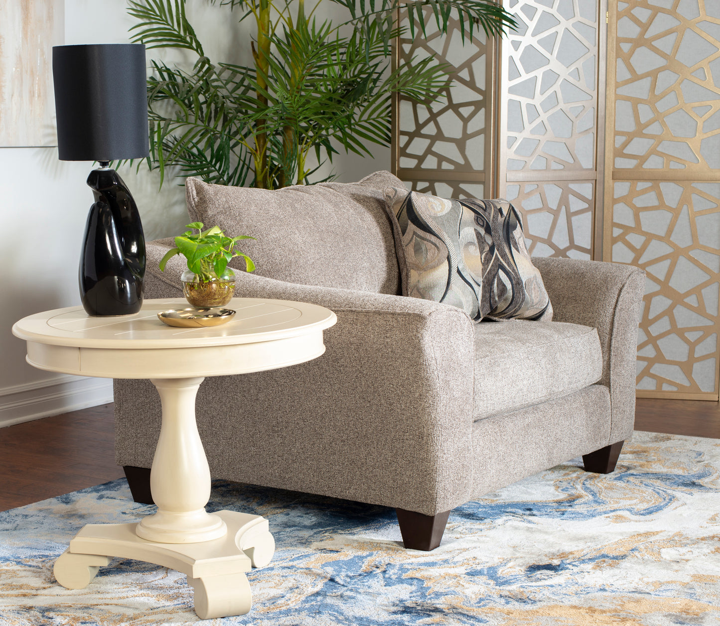 Textured beige armchair with a geometric patterned pillow and a cream side table