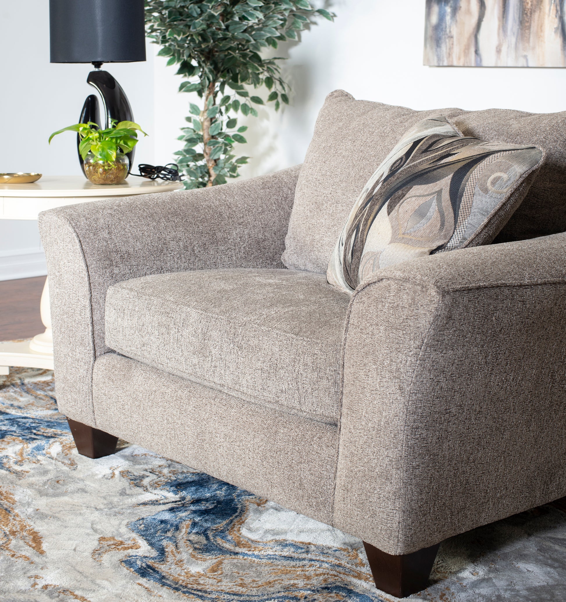 Cozy taupe textured armchair with a patterned throw pillow perfect for living room comfort