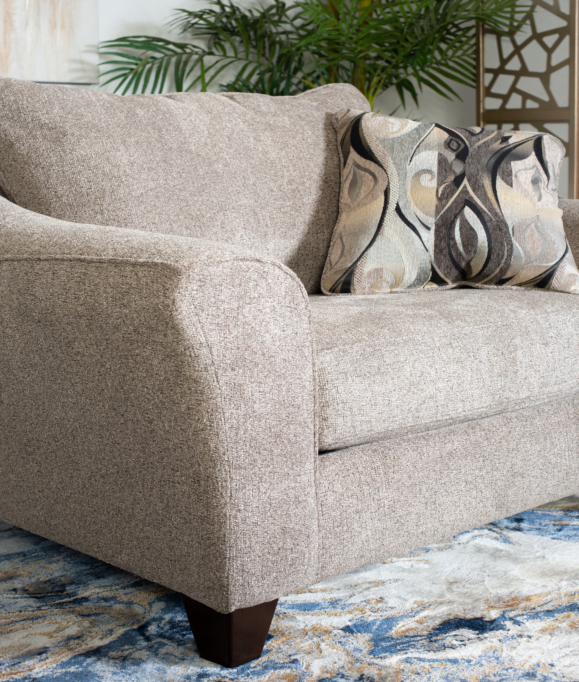 Plush beige fabric armchair with a decorative geometric print accent pillow for living room comfort
