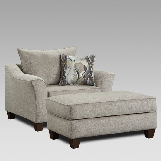 Comfortable grey fabric armchair with matching ottoman and decorative pillow