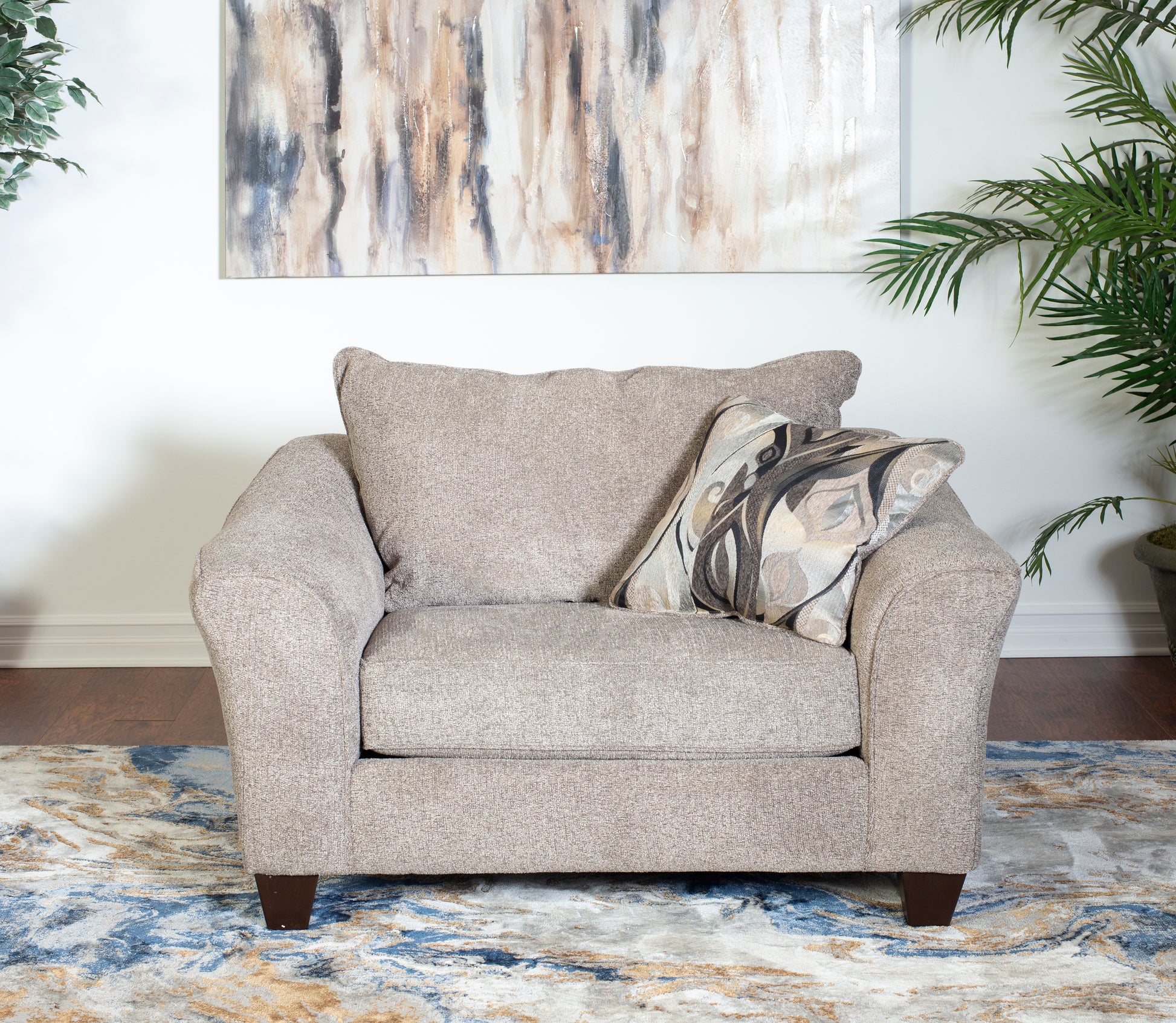 Comfortable beige fabric armchair with a decorative accent pillow perfect for living rooms
