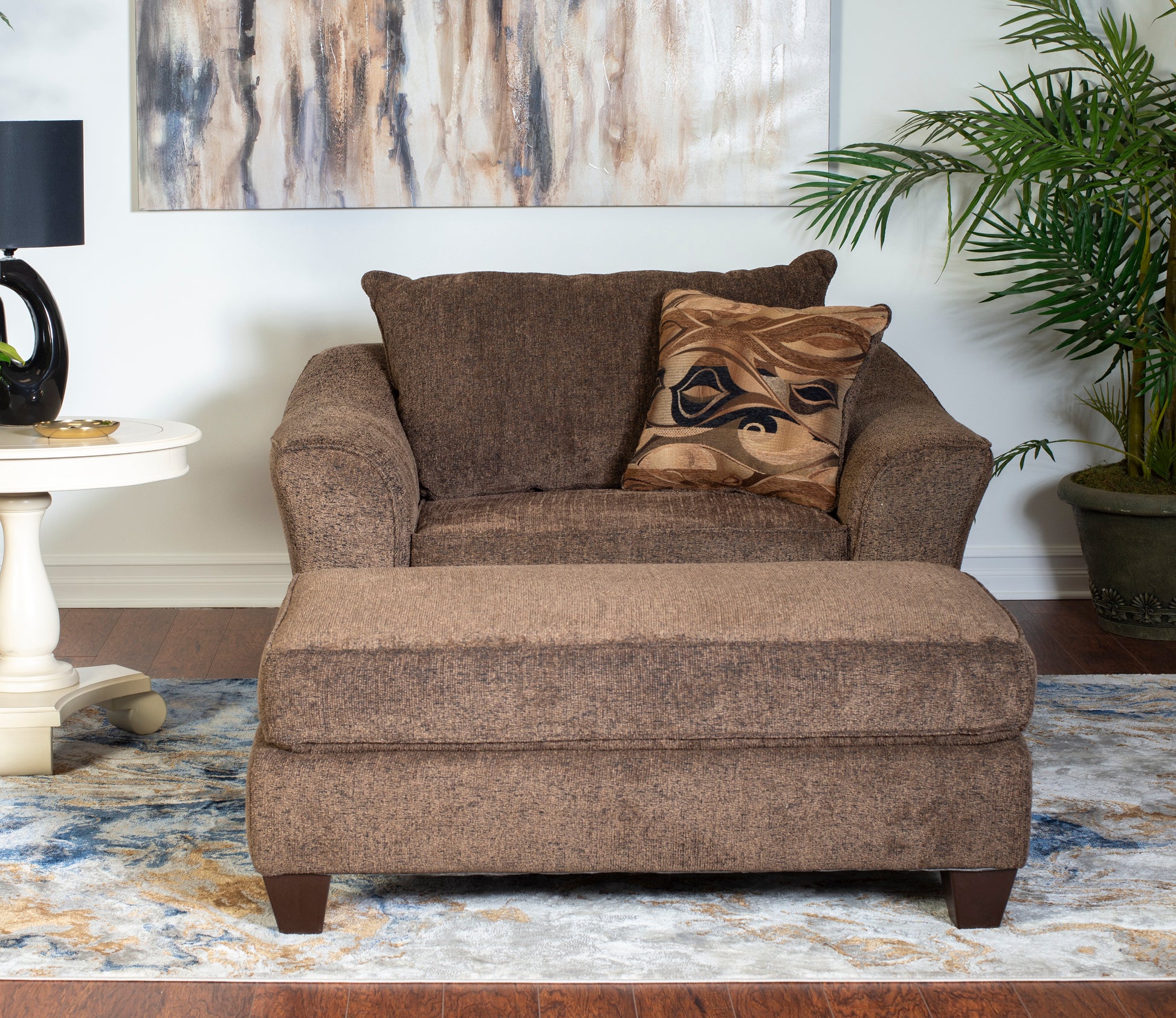 Plush brown textured armchair with matching ottoman and decorative throw pillow