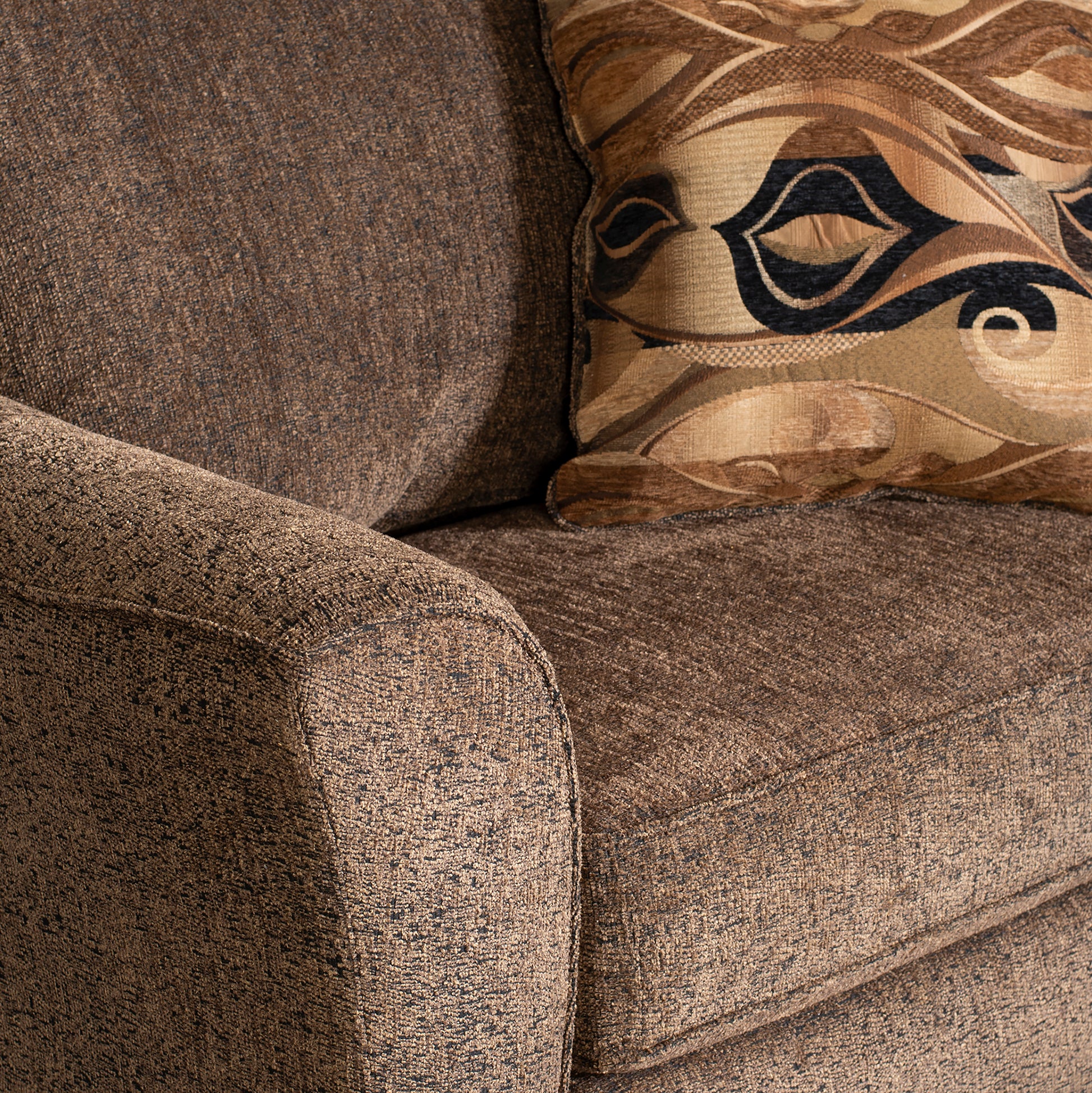 Brown textured sofa with a decorative patterned throw pillow perfect for living room comfort