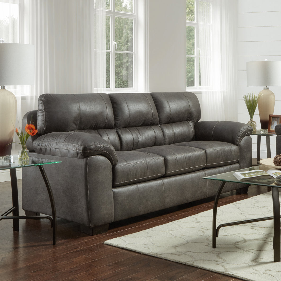 Dark grey faux leather sofa with detailed stitching and plush cushions