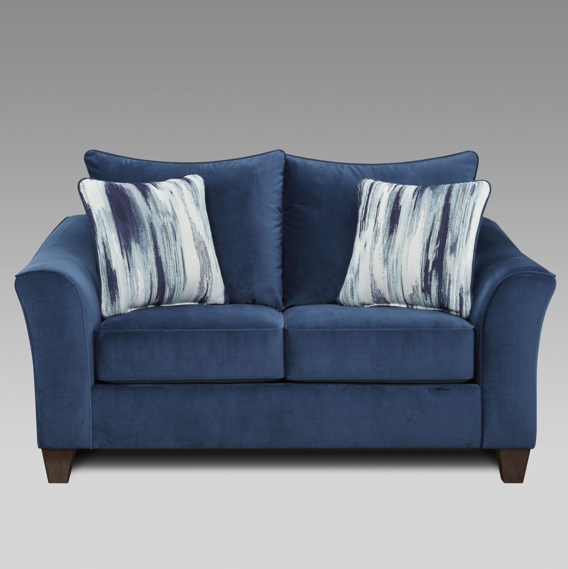 Navy blue velvet loveseat with abstract blue and white throw pillows