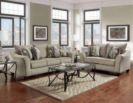 Taupe fabric sofa with abstract patterned throw pillows on a hardwood floor