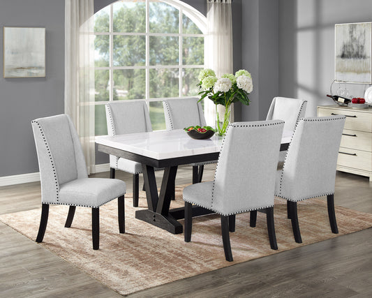 Elegant light gray upholstered dining chairs with nailhead trim paired with a marblelook dining table