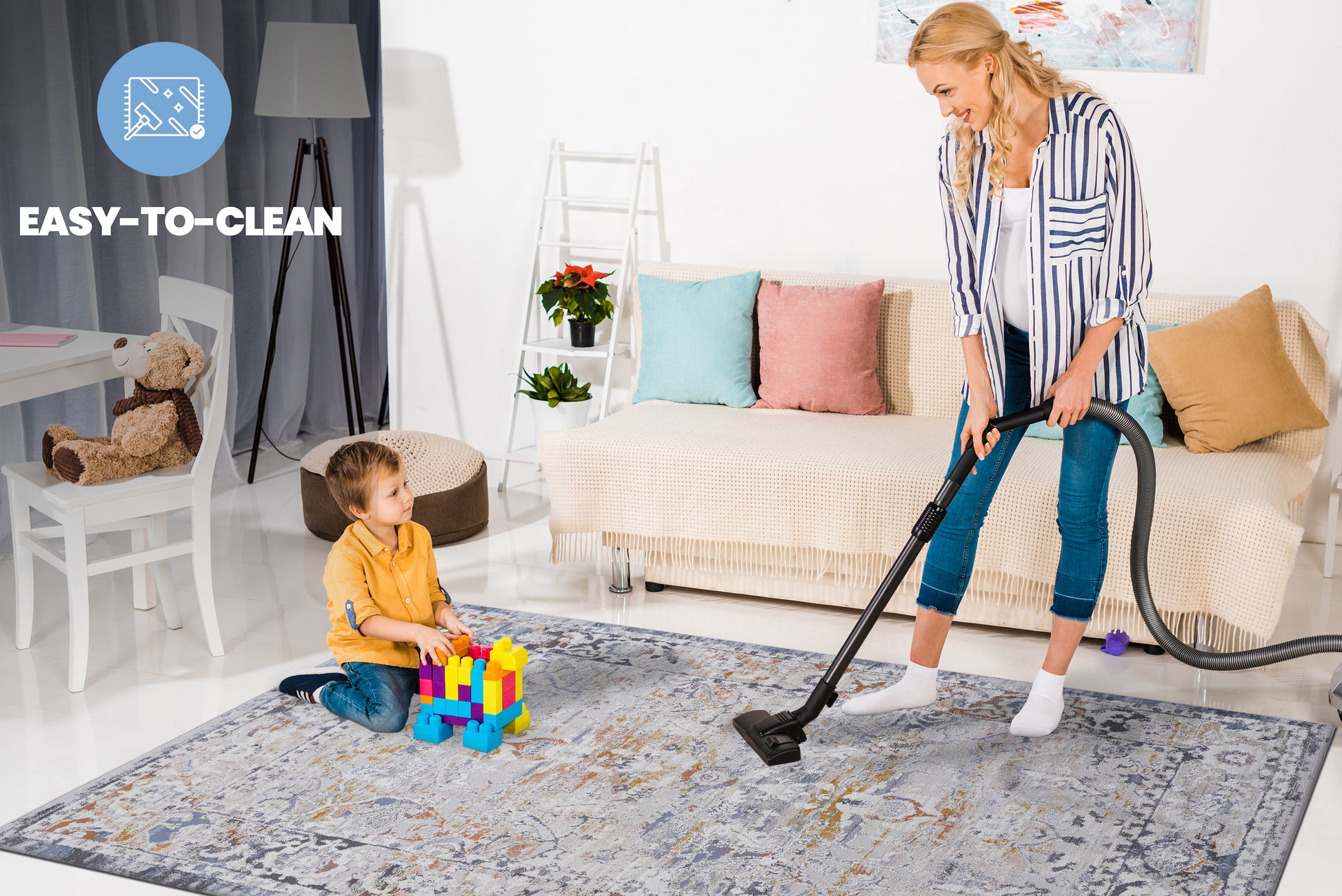 Grey abstract pattern area rug being vacuumed by a woman family friendly