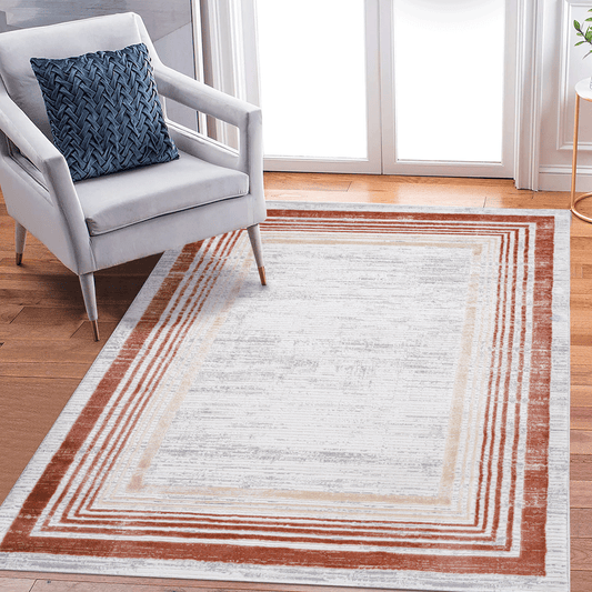 Modern abstract rug with rust and cream concentric stripes on a distressed white base
