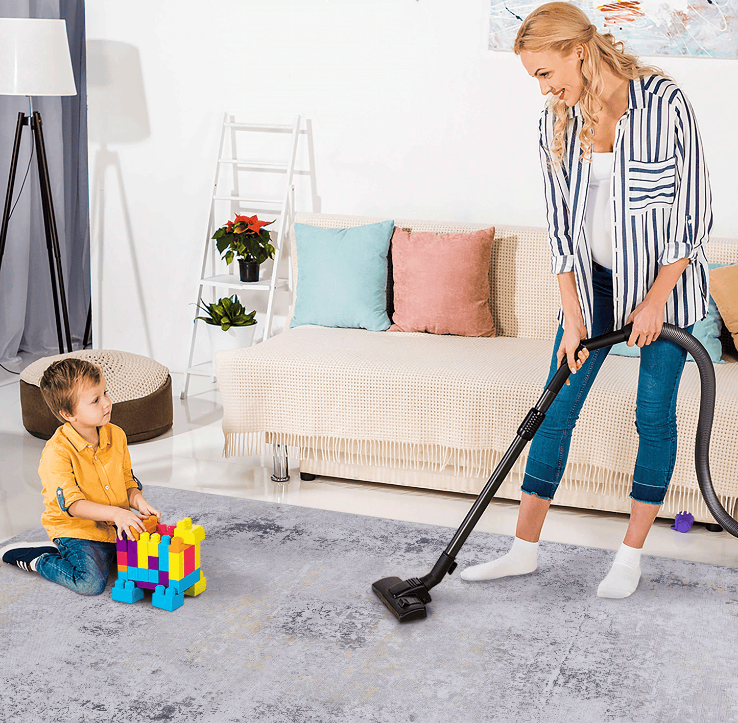 Woman vacuuming a distressed grey area rug with yellow and black accents