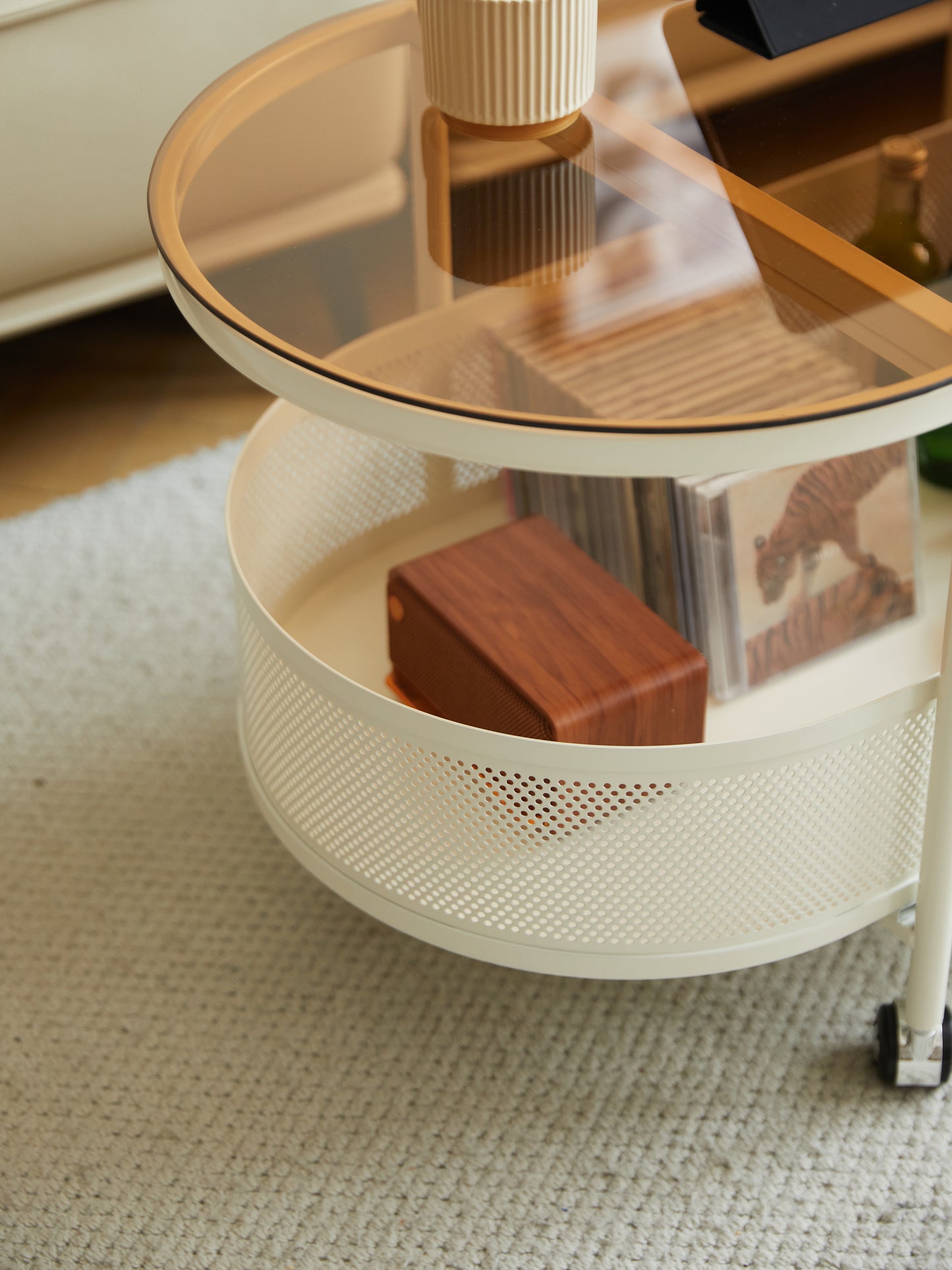 Cream rolling cart with amber glass top and wood speaker