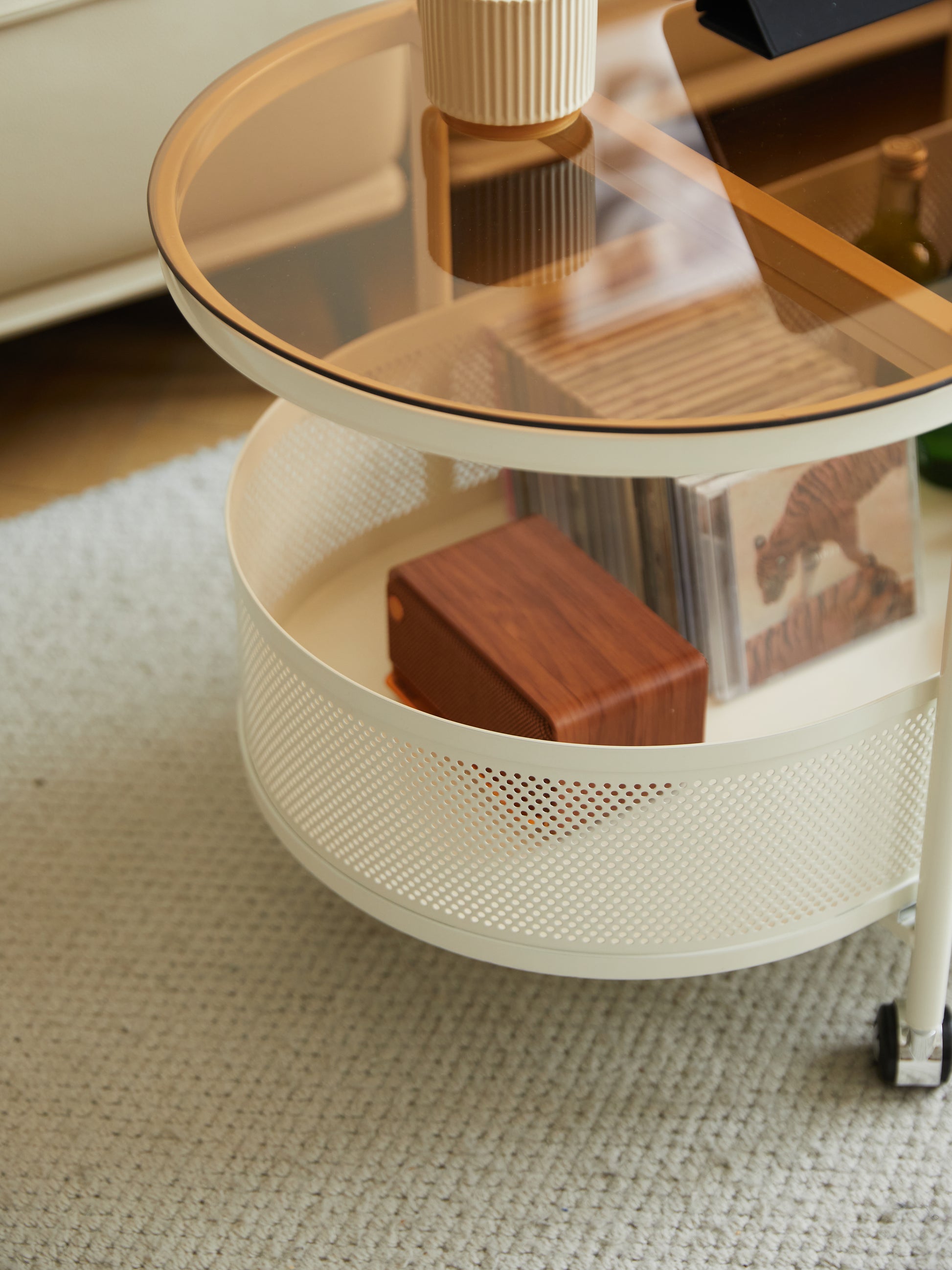 Cream rolling cart with amber glass top and wood speaker