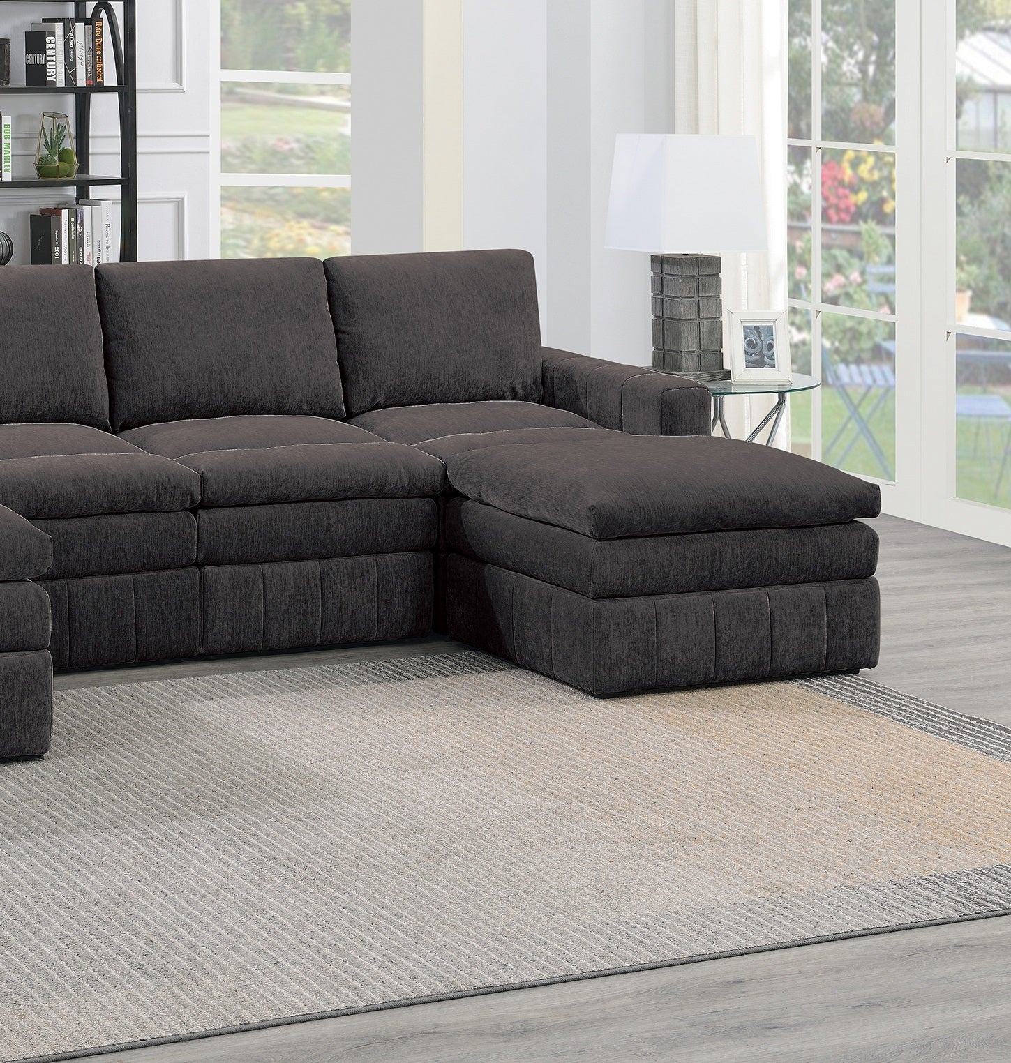 Dark grey fabric sectional sofa with a large ottoman perfect for modern living rooms