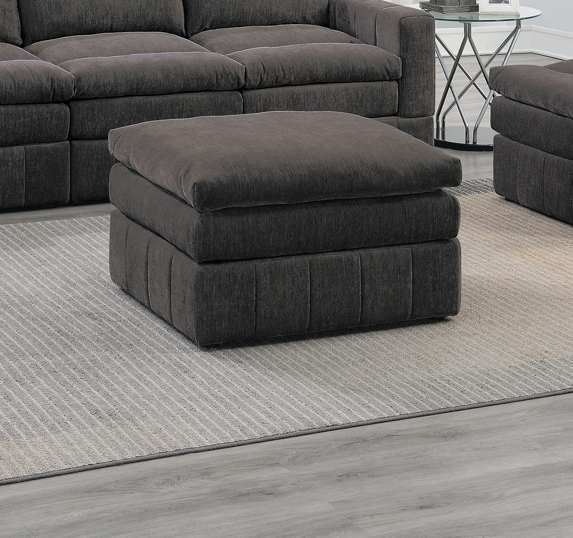 Plush charcoal grey square ottoman with tufted base and soft cushion top