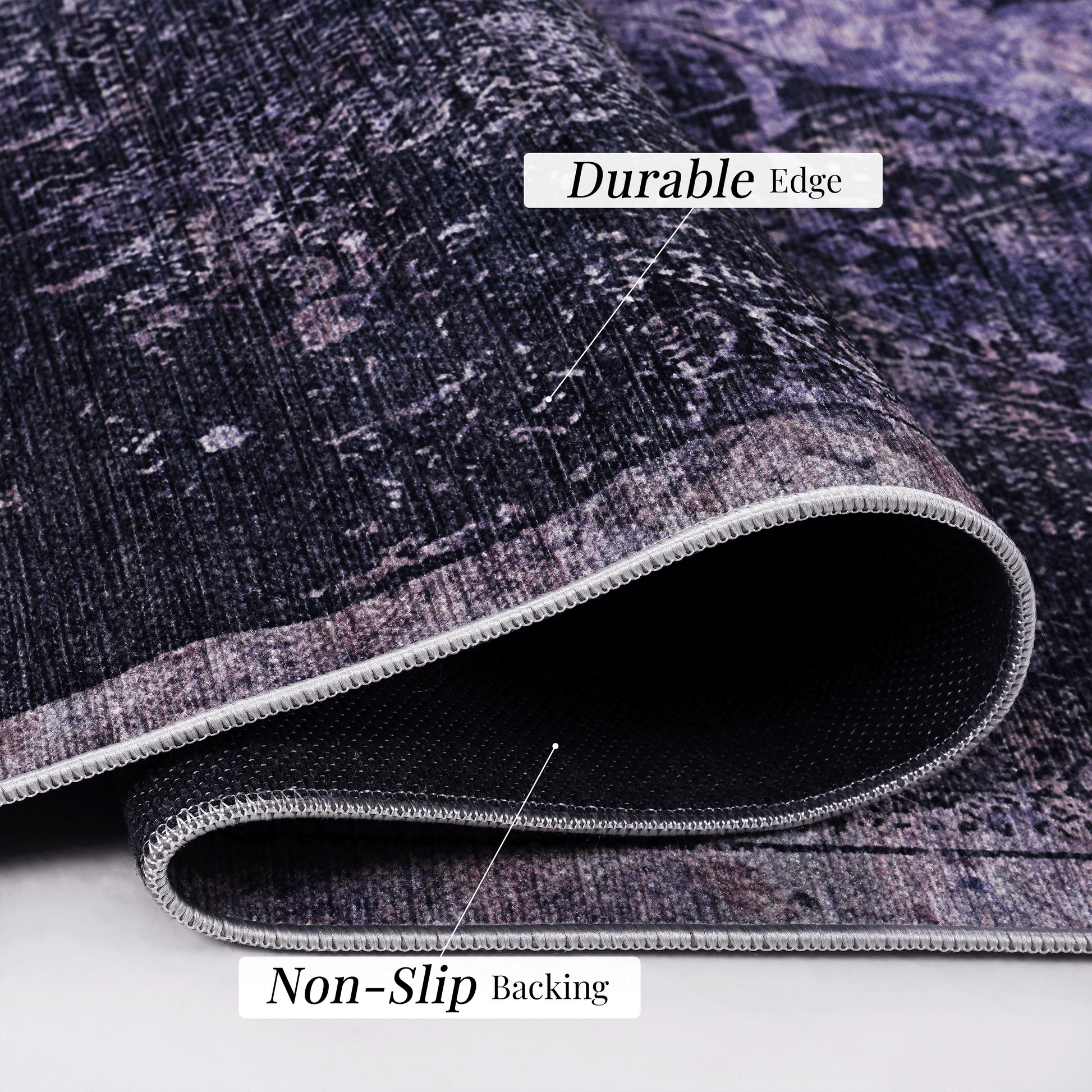 Closeup of a dark purple abstract pattern rug with a durable stitched edge and nonslip backing
