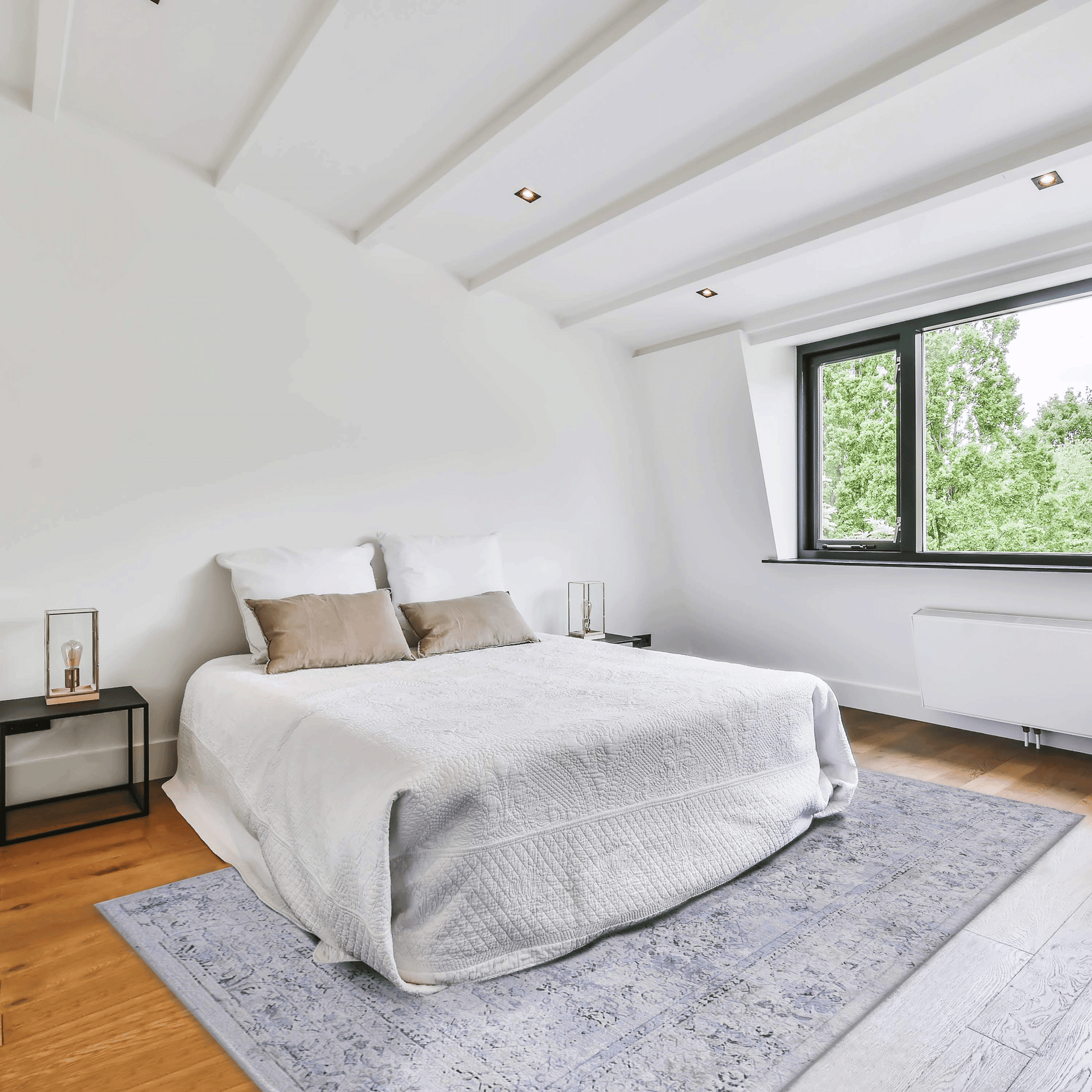 Elegant white quilted bedspread with two neutral accent pillows on a kingsize bed