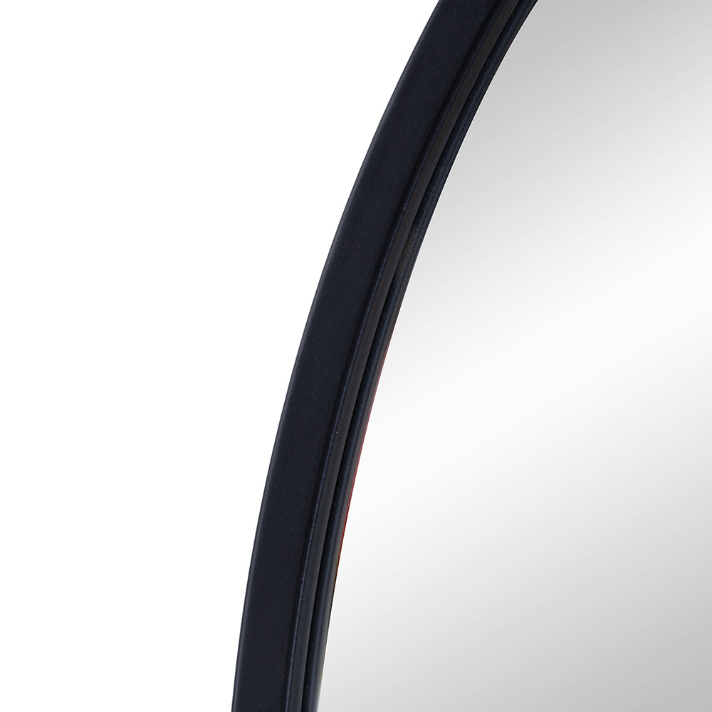 Closeup of a round black metal framed mirror edge reflecting white background