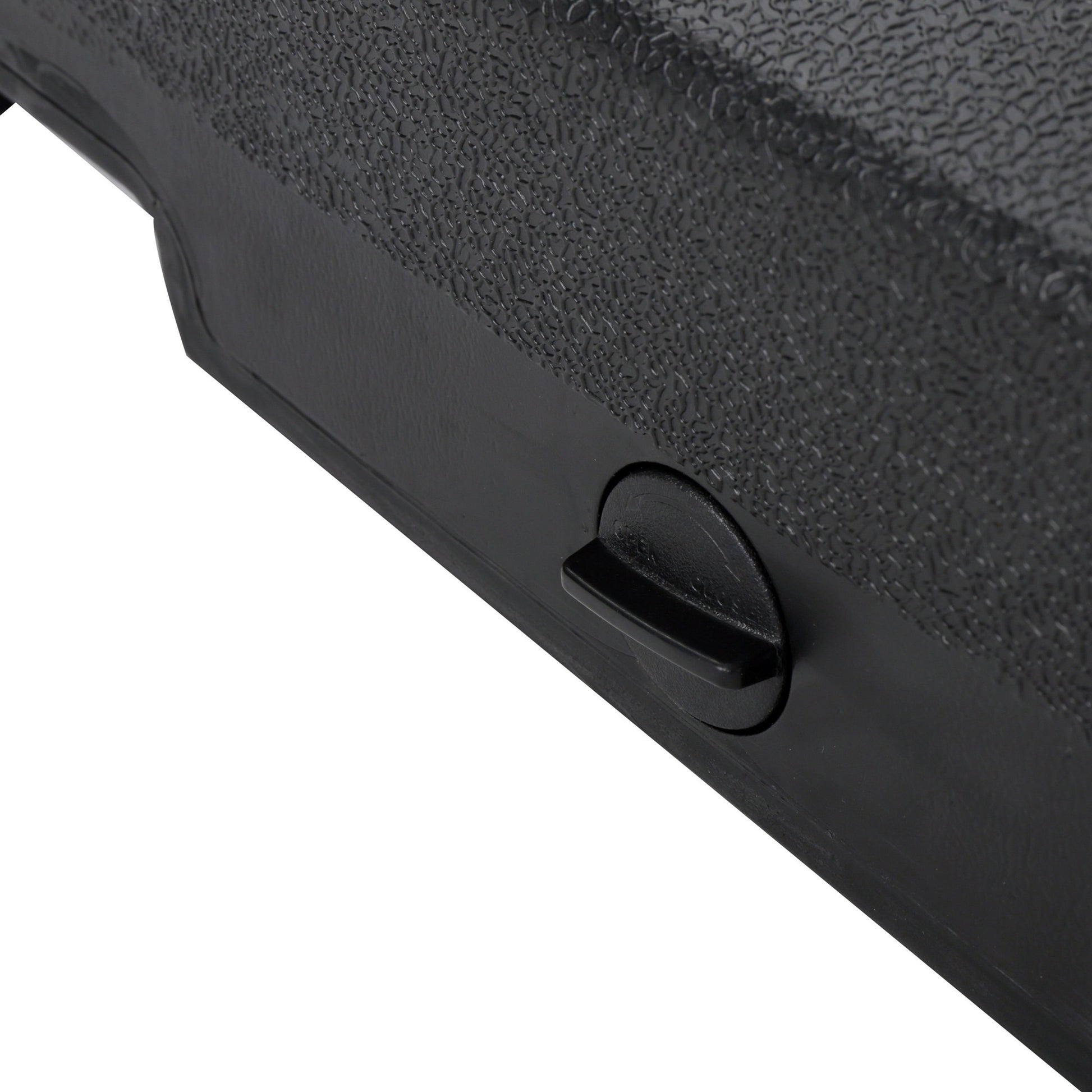 Closeup of textured black plastic with a molded knob and smooth edge