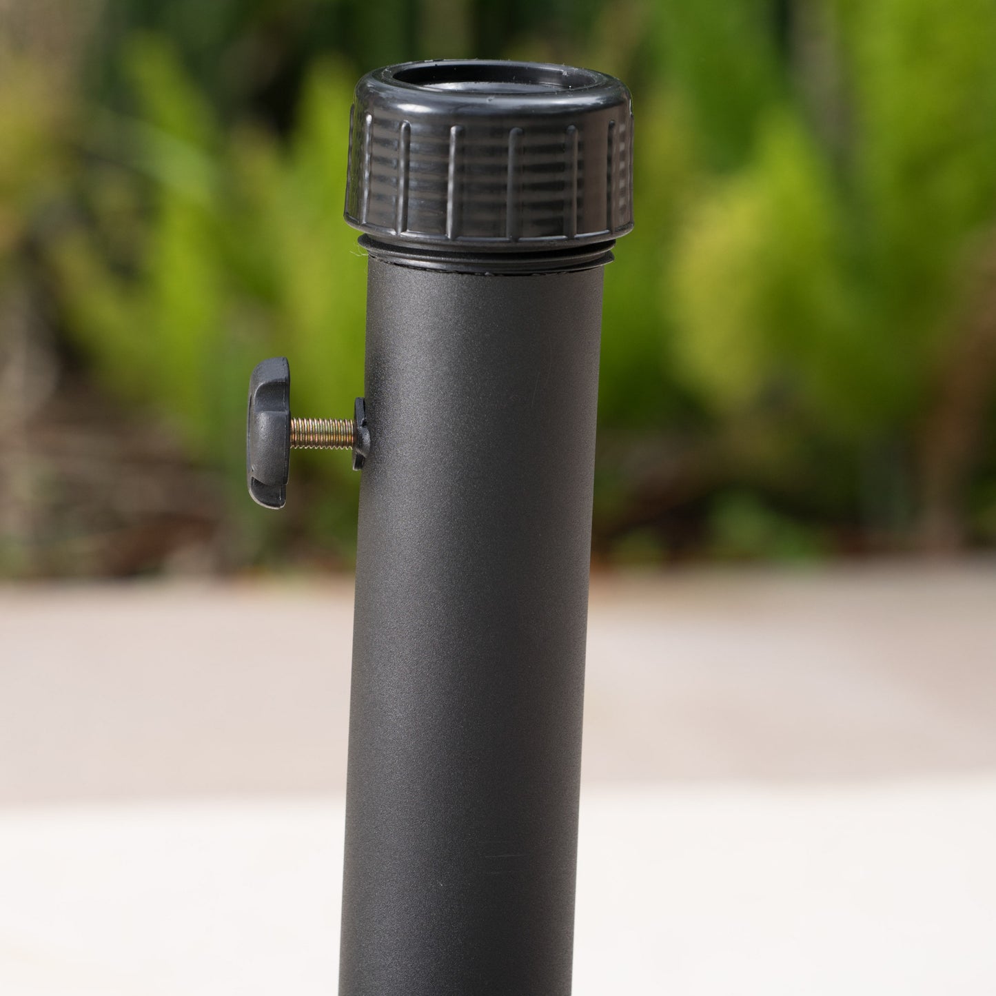Black umbrella pole with adjustable knob and threaded cap for outdoor stability