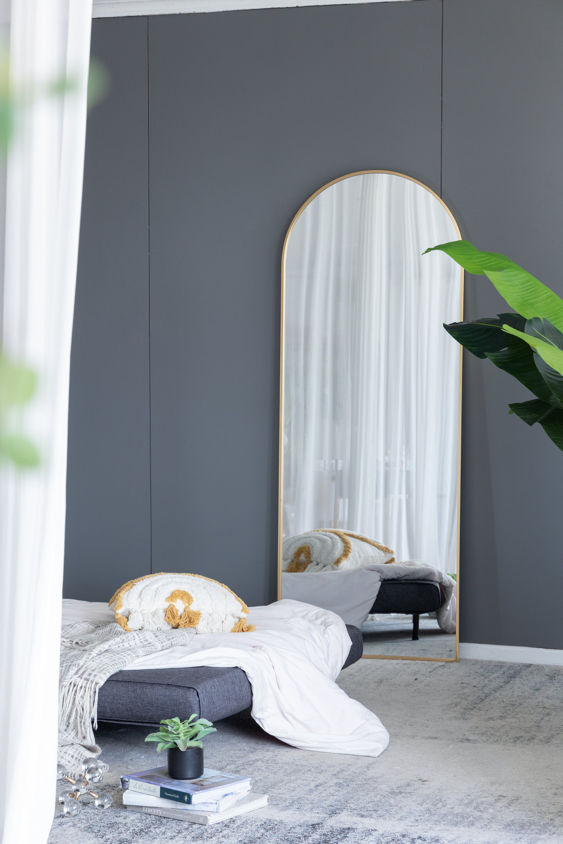 Tall arched floor mirror with gold metal frame perfect for modern bedrooms