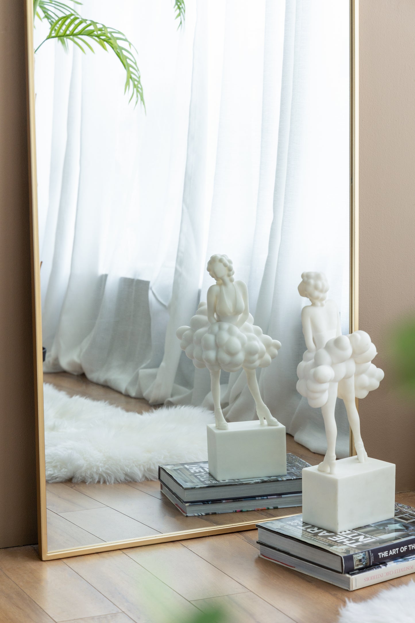 White resin ballerina figurine with a cloudlike skirt displayed on books