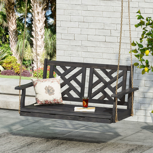 Dark wood garden swing with decorative backrest and floral pillow perfect for outdoor relaxation
