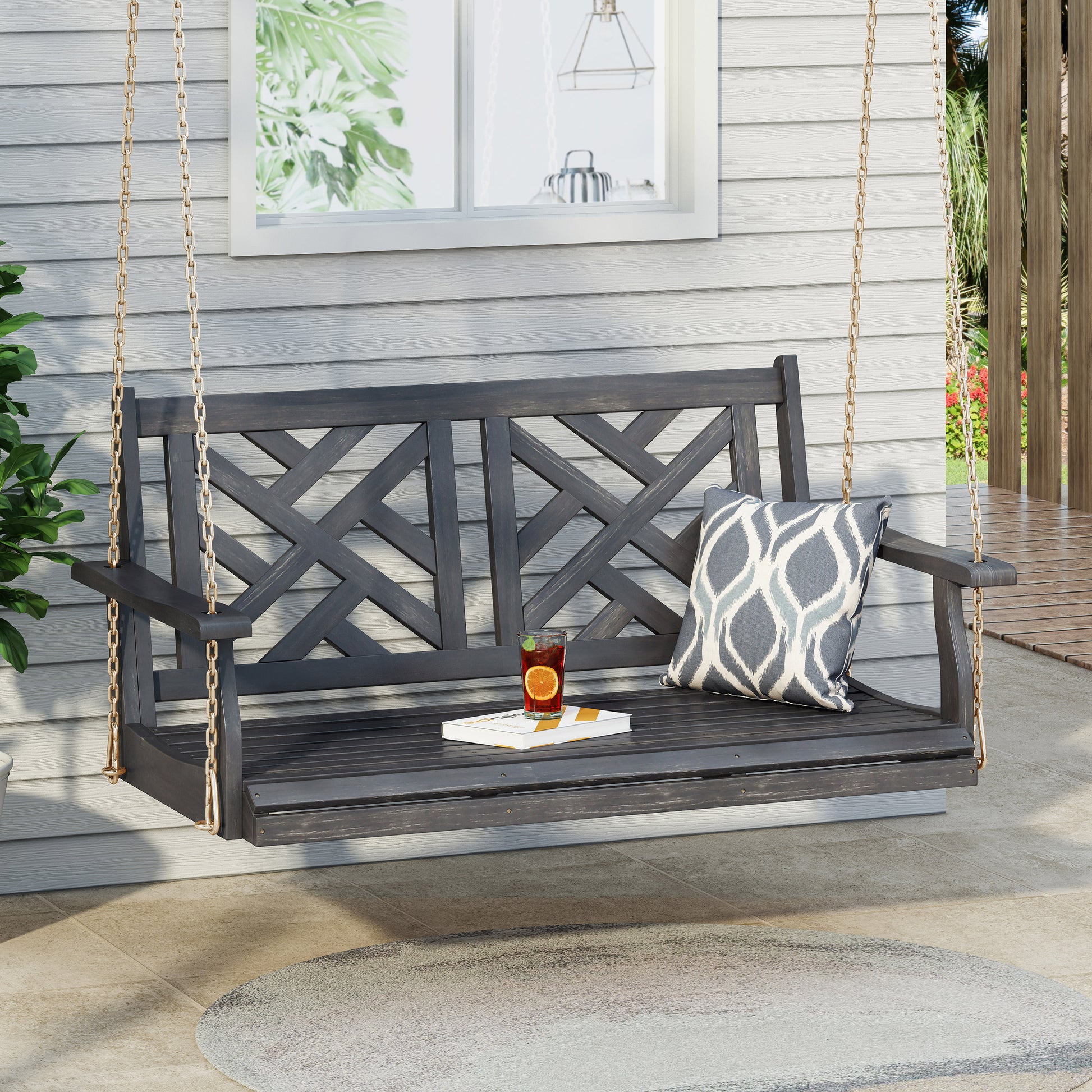 Dark gray wooden porch swing with ornate crisscross back design and gold chains