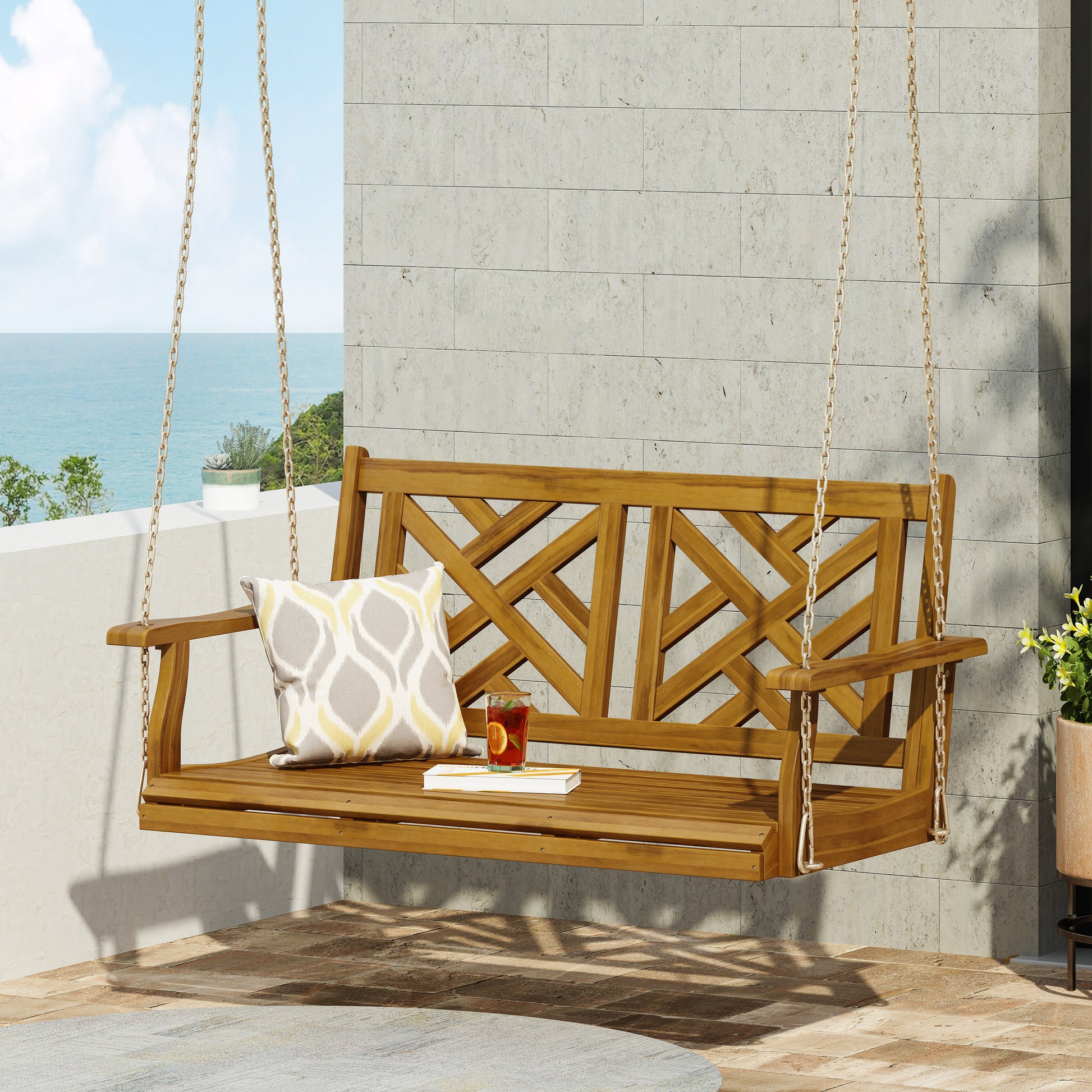Wooden acacia porch swing with lattice back and cream geometric pillow