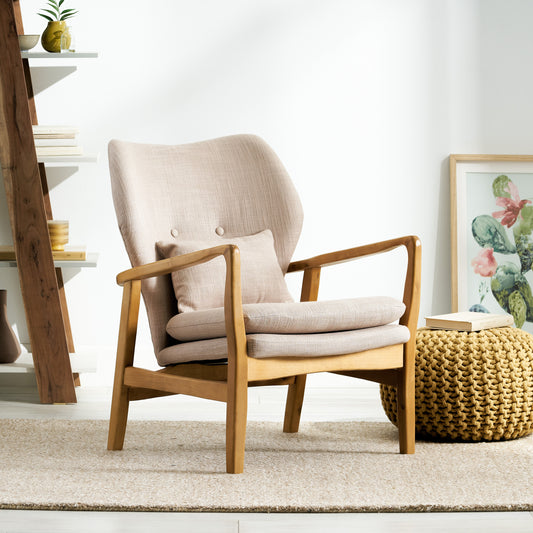 Beige fabric armchair with light wood frame accent pillow and woven pouf
