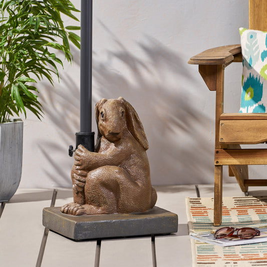 Brown resin bunny statue holding umbrella pole on a patio floor