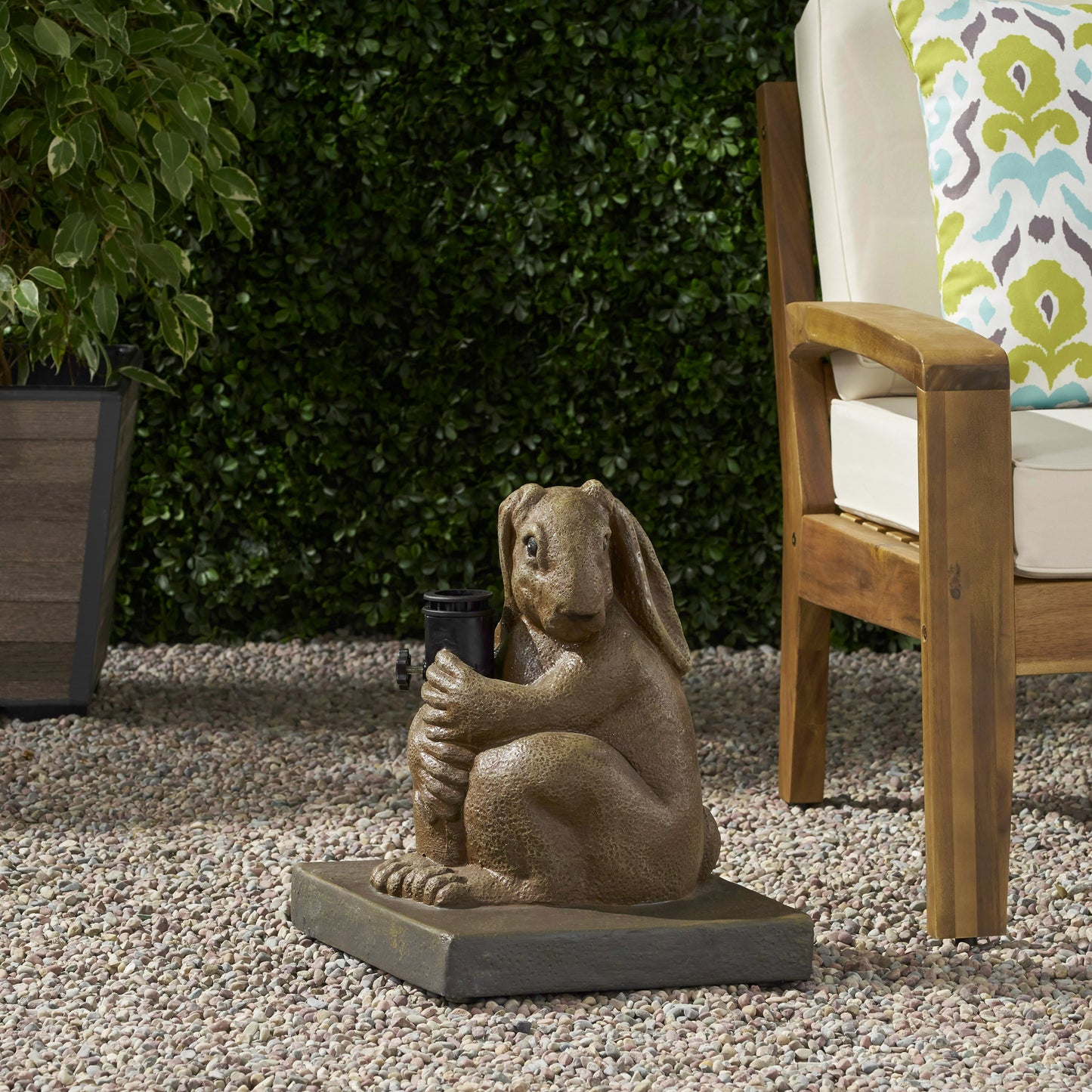 Resin garden statue of a brown rabbit holding a black garden light adds charm to outdoor spaces