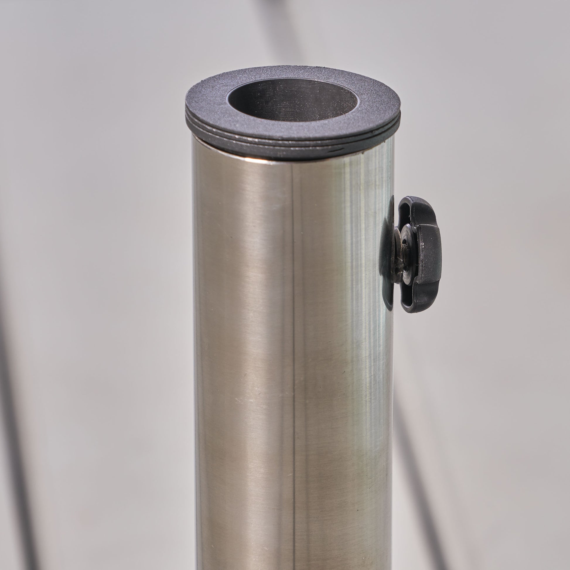 Brushed stainless steel umbrella stand with black plastic top ring and adjustable knob