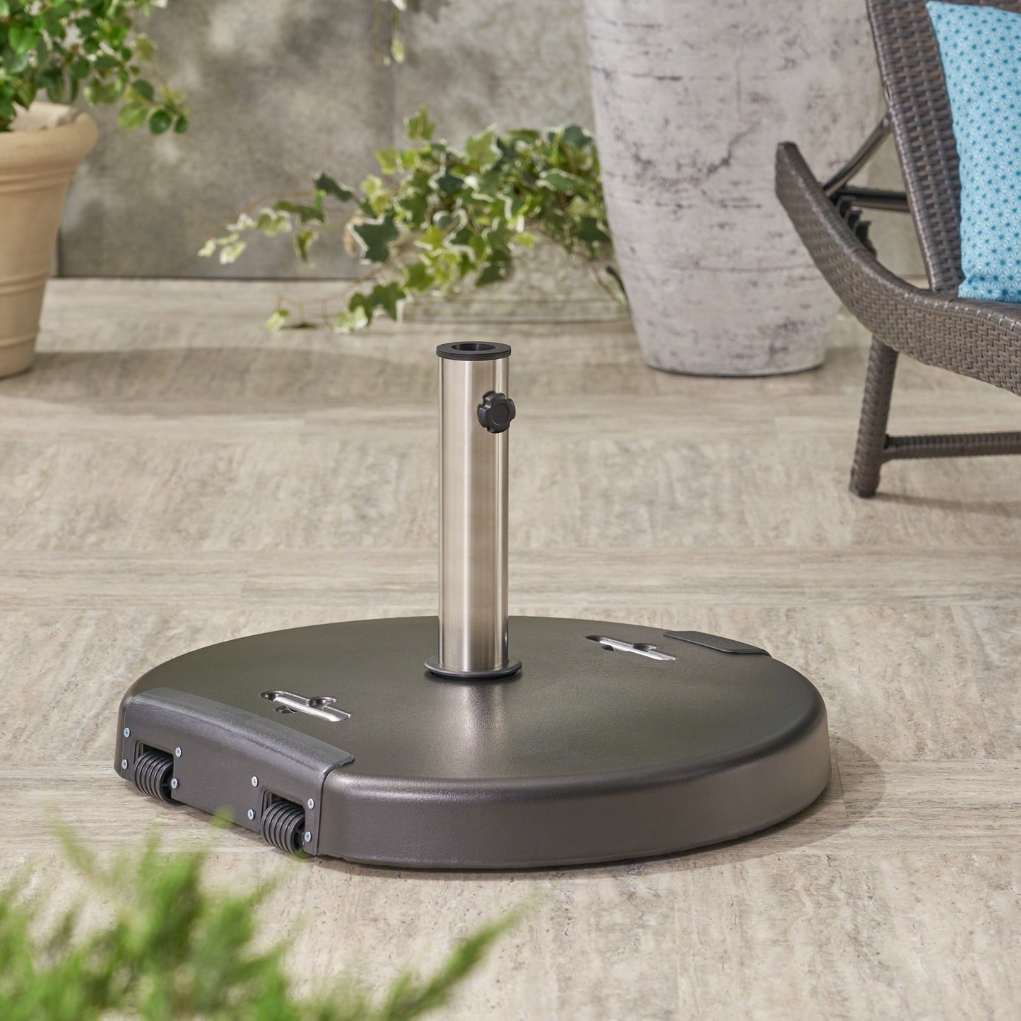 Dark grey rolling patio umbrella base with silver pole and black knob