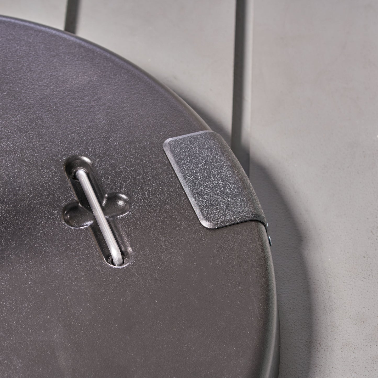 Dark gray plastic luggage handle detail with silver metal support