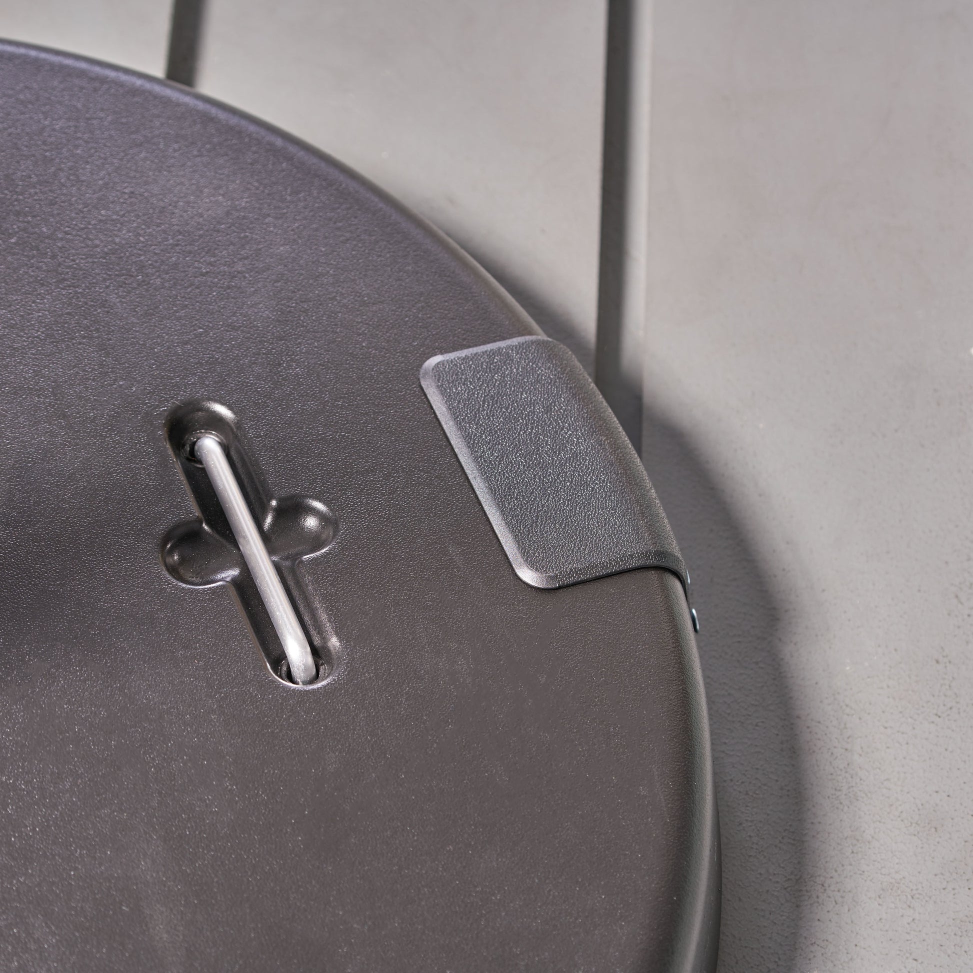 Dark gray plastic luggage handle detail with silver metal support