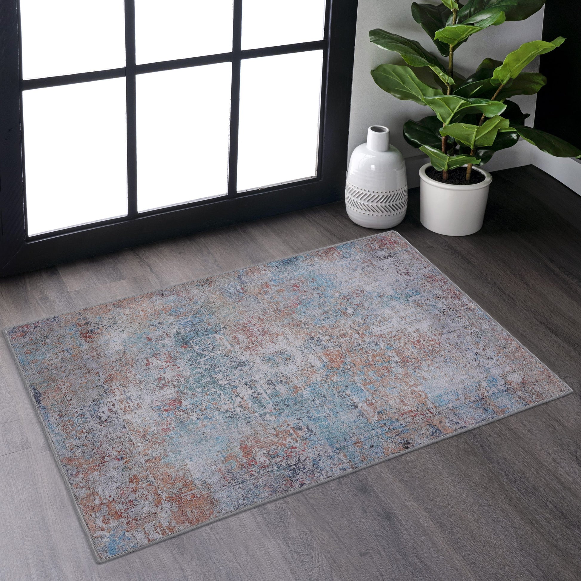 Distressed oriental area rug with blue coral and grey hues on a grey wood floor