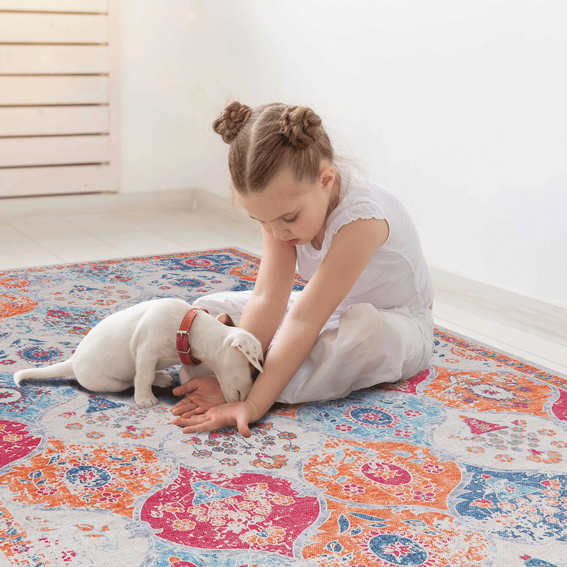 Distressed medallion area rug in orange blue and pink with a white puppy playing on it