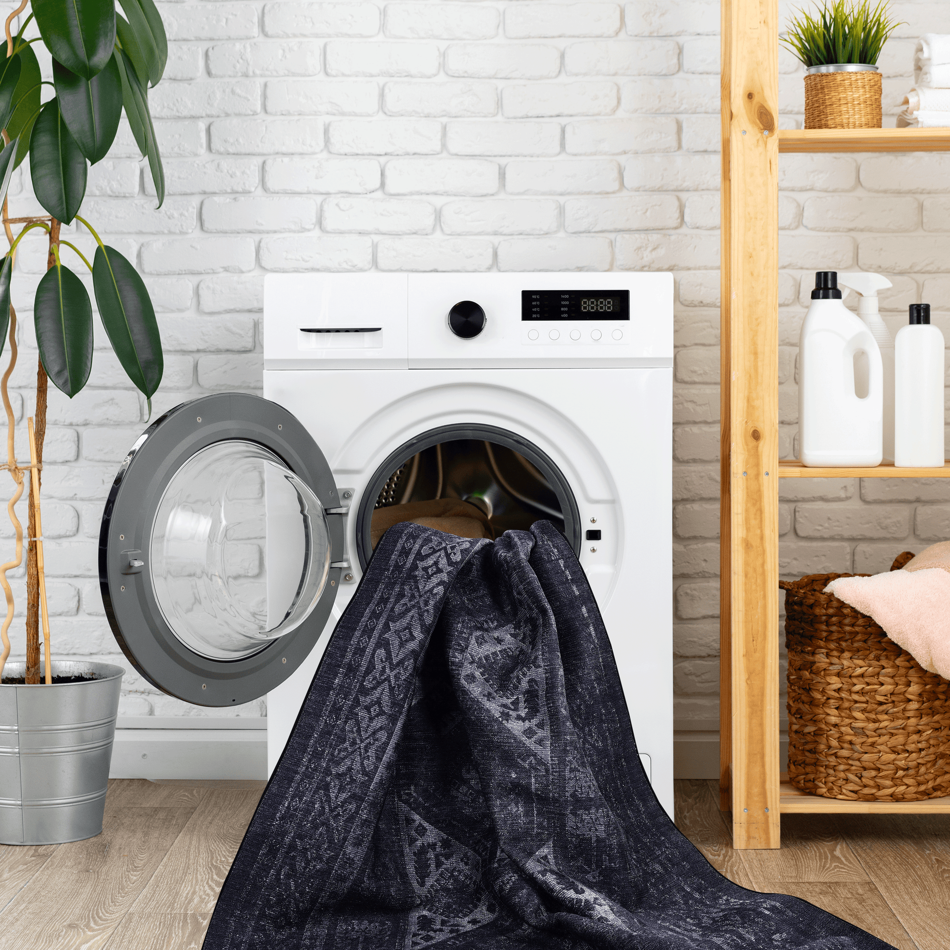Dark blue abstract pattern area rug draped partially into a washing machine