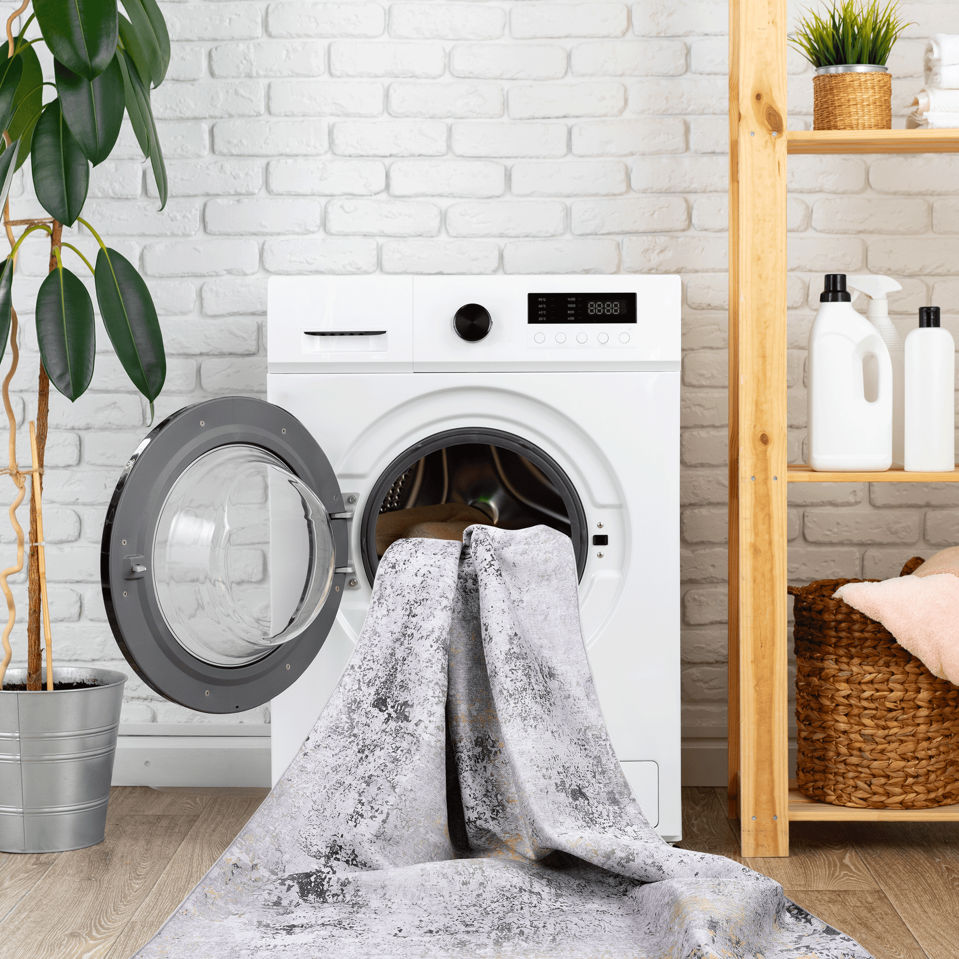 Abstract grey and gold distressed rug draped over an open washing machine drum