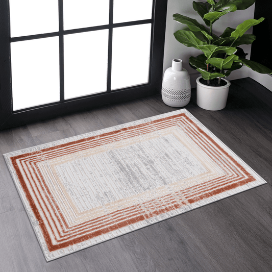 Rectangular area rug with concentric rectangle border in terracotta and beige on offwhite background