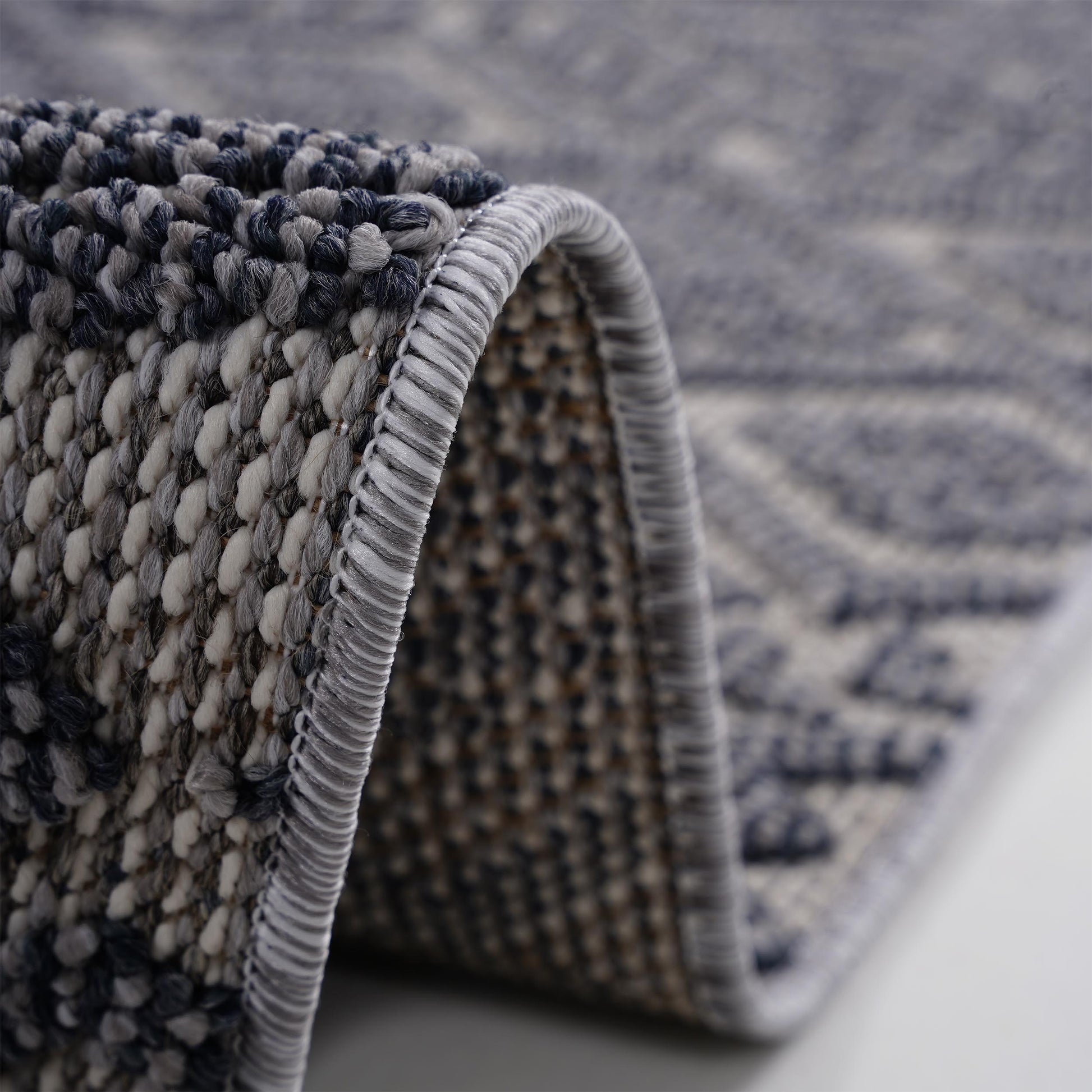 Closeup of a textured blue and grey geometric rug showcasing its plush weave