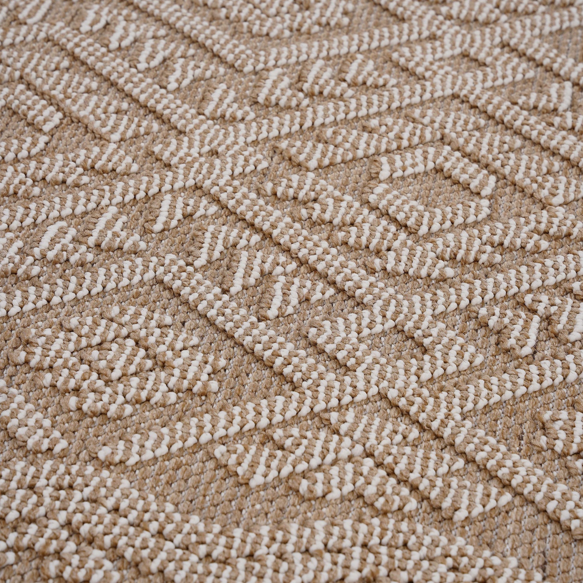 Closeup of a textured rug with a diamond pattern in beige and cream jute fabric