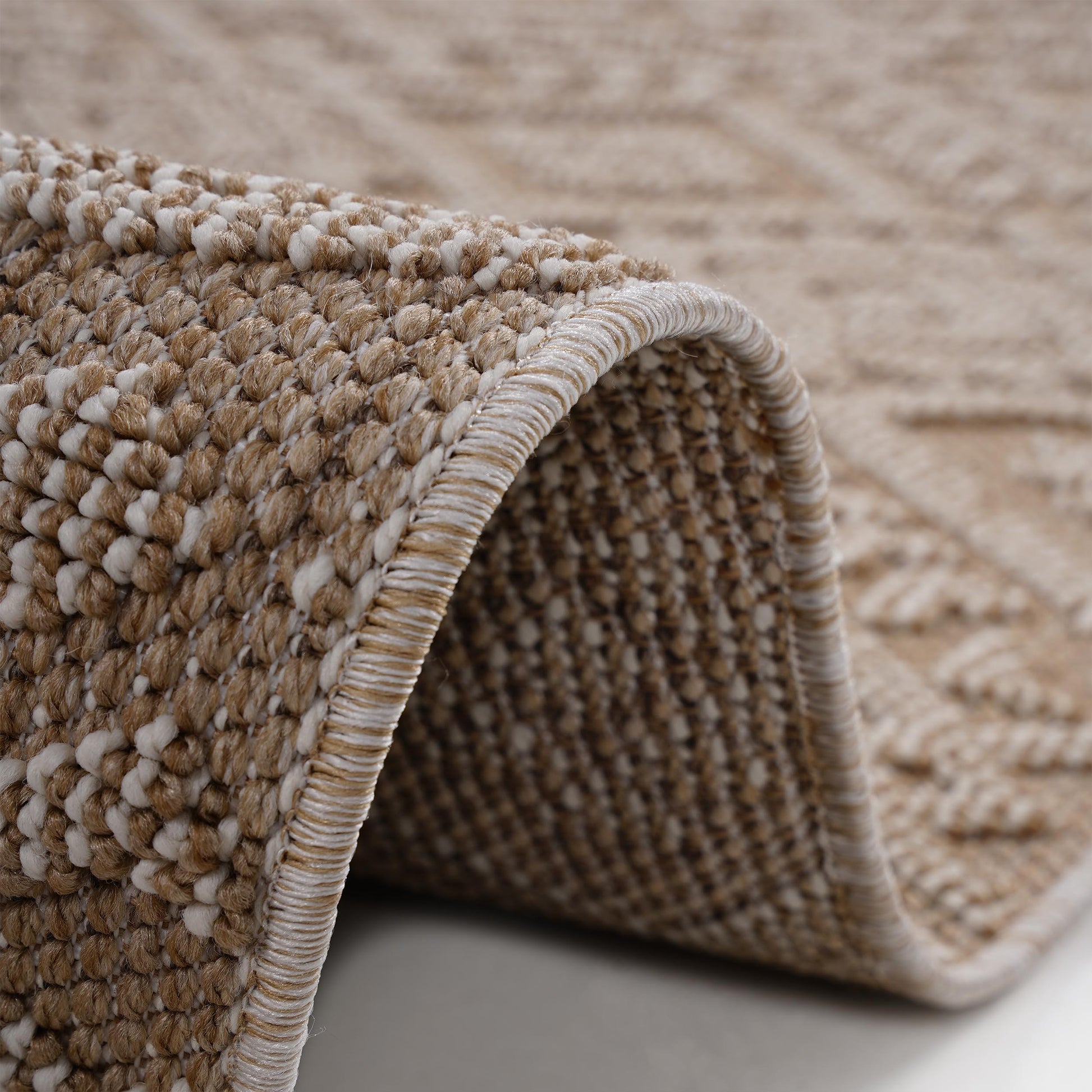 Textured beige and white woven rug with diamond pattern detail