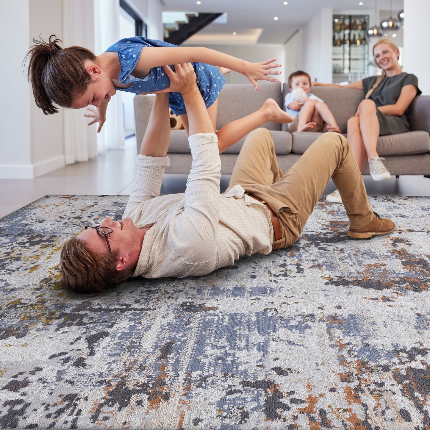 Modern abstract area rug in grey white and rust hues adding texture to living room floors