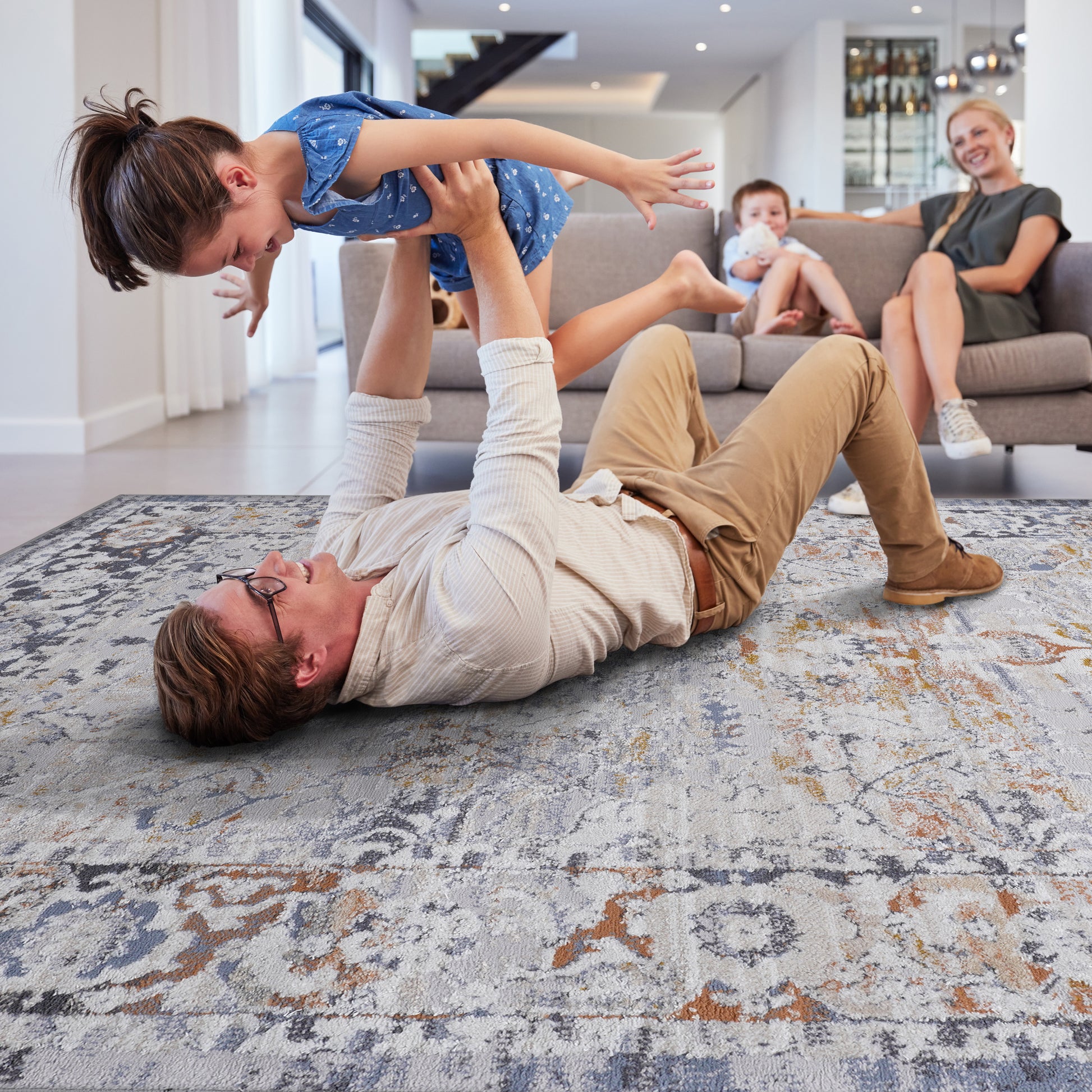 Distressed abstract rug in muted grey blue and rust tones adds character to living room