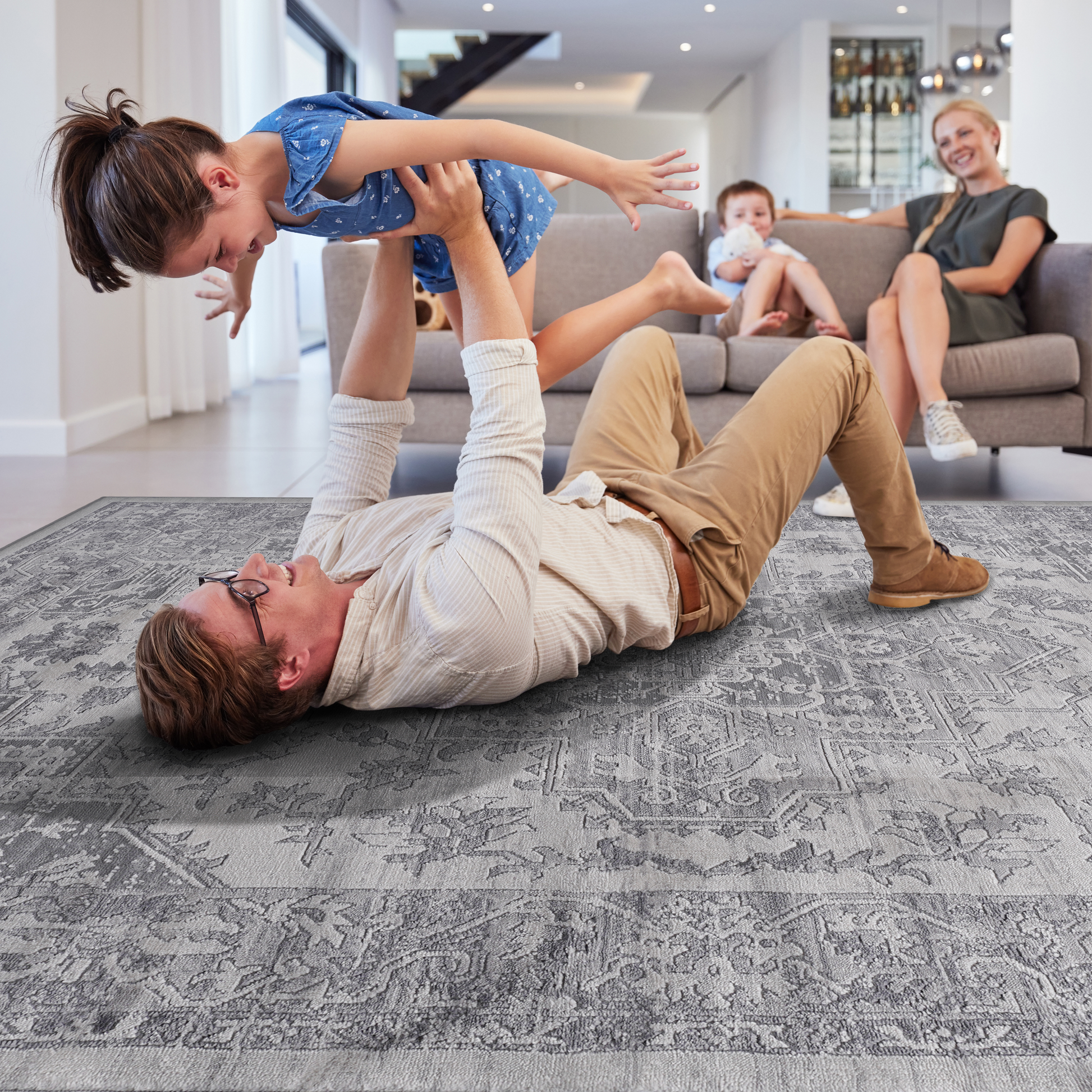 Gray Persian rug with intricate traditional patterns providing a soft surface for family play